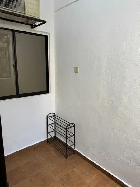 Room features: white painted walls, brown tiled flooring, window with black frame, metal shoe rack.