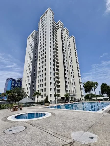 Exterior type: high-rise condominium; features: white painted facade, glass curtain wall, recessed balconies, infinity pool, jacuzzi, pool deck with loungers, manicured landscaping, surrounded by palm trees, approximately 15-storey high-rise, modern architectural style; style: modern.