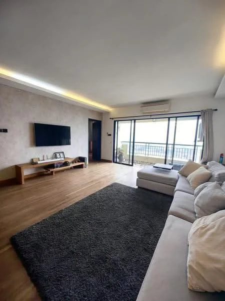 Living features: light wood flooring, white painted walls, recessed LED downlights, wall-mounted TV, wooden TV console, large sliding glass door, floor-to-ceiling windows, grey area rug, L-shape sectional sofa in light fabric, air conditioning unit; style: modern; view: sea.