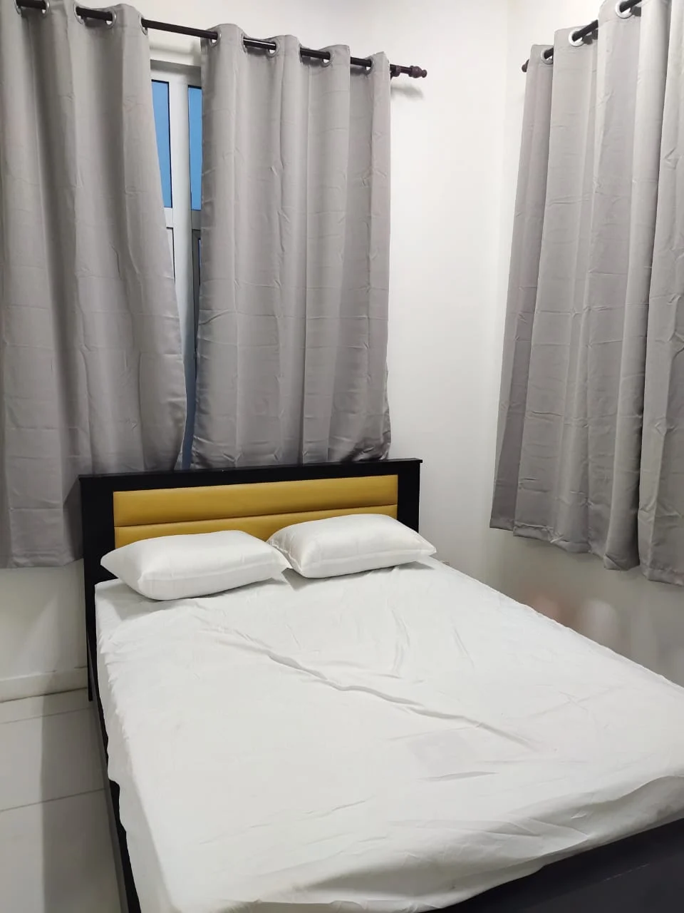 Bedroom features: queen-size bed, white bedding, black bed frame, grey curtains, floor-to-ceiling window, white walls, tile flooring; style: modern.