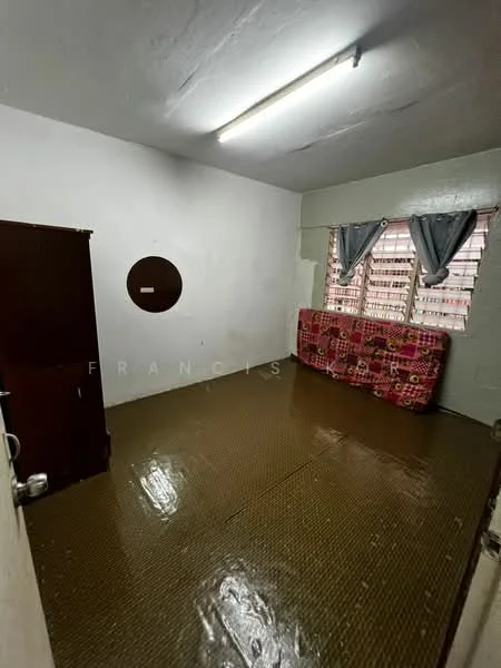 Room features: white painted walls, vinyl flooring, window with sheer curtains, ceiling light fixture, wooden wardrobe, decorative wall circle, corner seating area with patterned fabric, exposed ceiling.