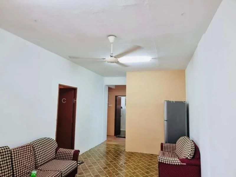 Living features: white painted walls, ceiling with no visible texture, 5-blade ceiling fan, tiled flooring in brown and yellow pattern, two fabric sofas in checkered pattern, refrigerator, doorway leading to another room.