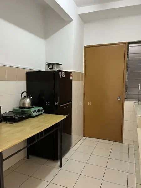 Kitchen features: black refrigerator, stainless-steel kettle, gas stove, wooden table, white tiled walls, cream tiled backsplash, light-colored countertop, window with metal grille, brown door.