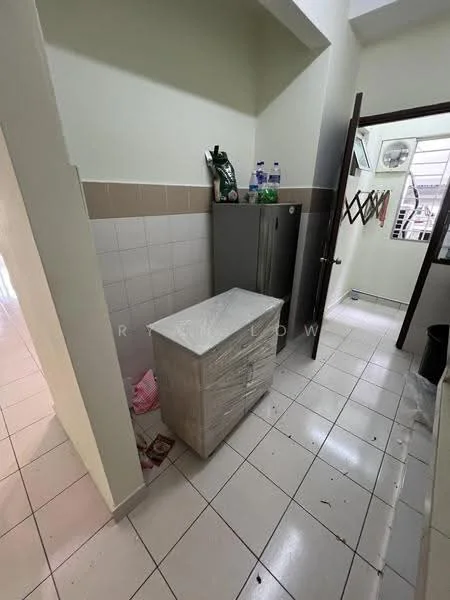 Kitchen features: white tiled walls, light grey countertop, stainless-steel fridge, white cabinet with drawers, ceramic tile flooring, wall-mounted air conditioning unit, open doorway, window with natural light.