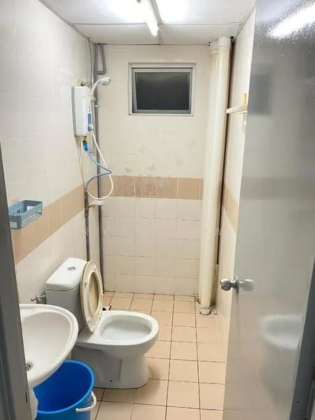 Bathroom features: white tiled walls, beige tiled wall accent, ceramic tile flooring, one-piece toilet, sink with pedestal, shower head, exposed plumbing, window for ventilation, light fixture on ceiling.