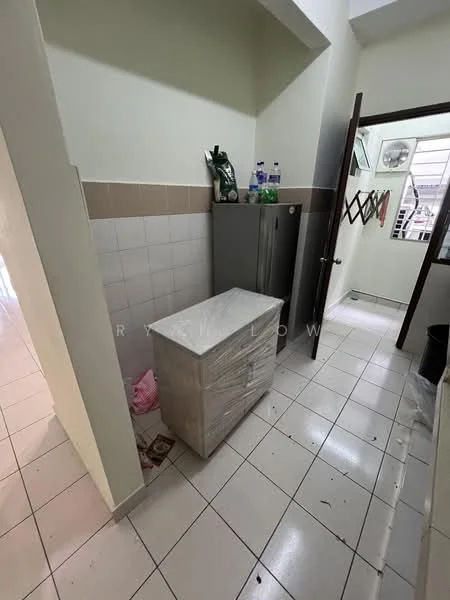 Room features: white tiled flooring, light green painted walls, grey refrigerator, white cabinet, wall-mounted air conditioning unit, window with natural light, door leading to another room, plastic bags on the floor.