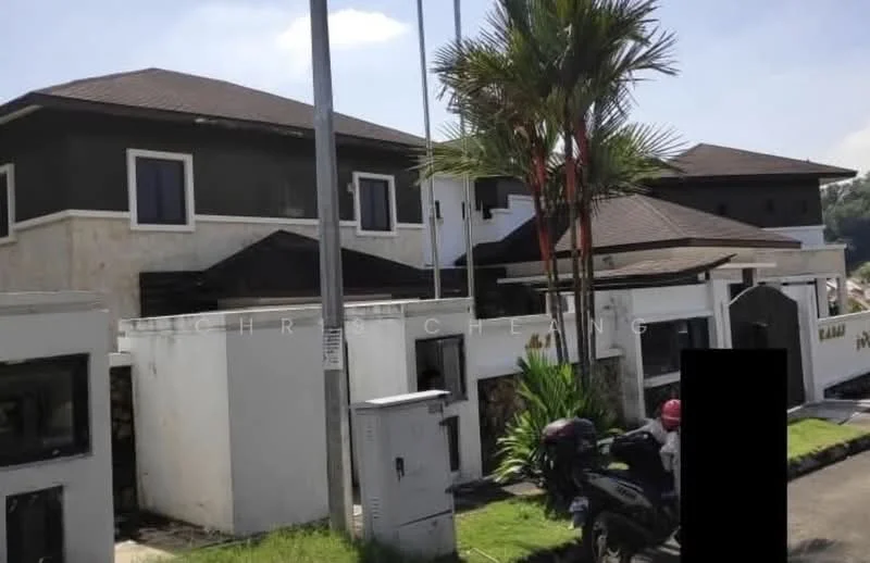 Exterior type: detached bungalow; features: two-storey building, dark grey painted facade, light stone cladding, pitched tile roof, manicured landscaping, palm trees, front driveway, visible parking area, multiple windows, entrance gate, decorative stone wall; style: modern.