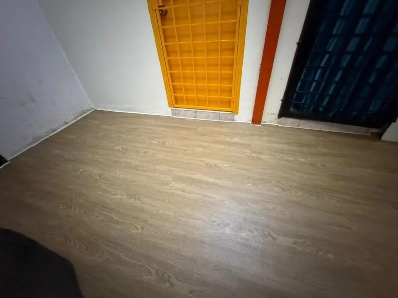 Room features: laminate flooring, white painted walls, orange door, black security door, tile baseboards.