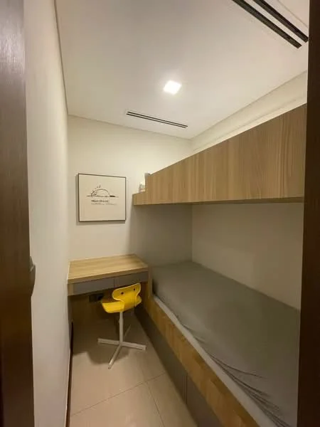 Room features: built-in wooden bed with storage underneath, light grey bedding, wooden desk with drawers, yellow swivel chair, white walls, recessed ceiling lights, floor-to-ceiling storage cabinets, glossy tile flooring; style: modern.