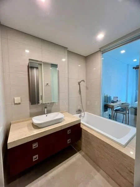 Bathroom features: single-sink vanity with wood cabinet, white ceramic sink, chrome basin mixer faucet, mirrored cabinet above sink, bathtub, shower with glass enclosure, wall-mounted shower head, cream marble countertop, light beige wall tiles, light beige floor tiles, recessed downlights; style: modern.