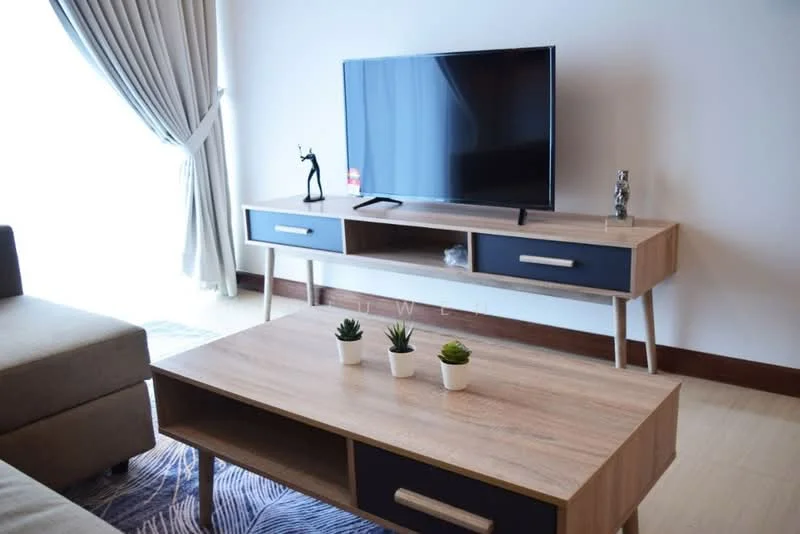 Living features: sofa in beige fabric, wooden coffee table, TV console with drawers, flat-screen TV, decorative figurine on console, succulent plants on coffee table, curtains in light fabric, area rug with geometric pattern, wooden flooring; style: modern.