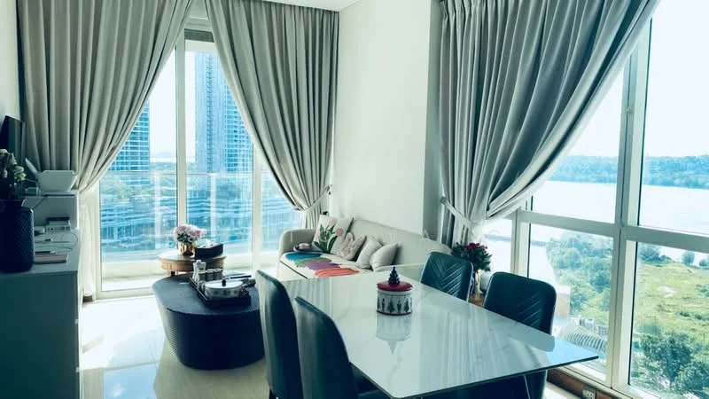 Dining features: white dining table, upholstered dining chairs, floor-to-ceiling windows, sheer curtains, grey fabric sofa, decorative throw pillows, coffee table, city view, wooden flooring, wall-mounted TV, decorative plants; style: modern; view: city.