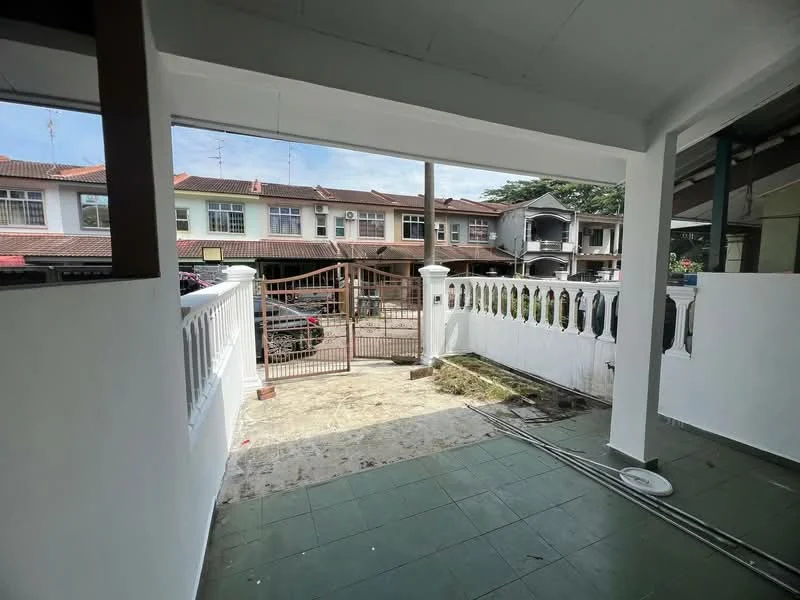 Exterior type: linked terrace house; features: white painted facade, green tiled flooring, gate at entrance, fenced yard, surrounded by residential buildings, driveway visible, manicured lawn, outdoor space with railing; style: modern.