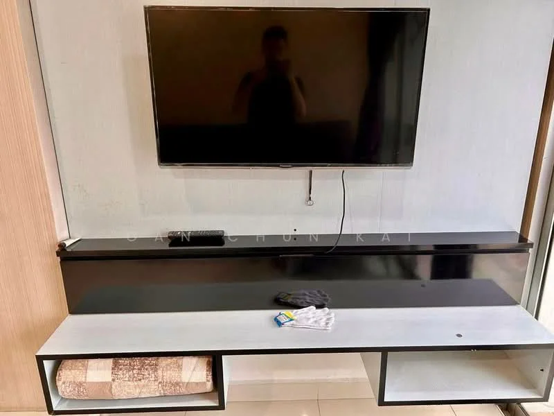 Living features: wall-mounted TV, black TV console, open shelving, cream wall, light-colored flooring, decorative throw blanket, remote control, cleaning cloth; style: modern.
