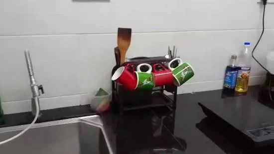 Kitchen features: single-bowl stainless-steel sink, chrome pull-down faucet, black granite countertop, kitchen utensils holder, red and green mugs, wooden spatula, bottle of cooking oil, bottle of liquid detergent, black stove, white tiled walls; style: modern.
