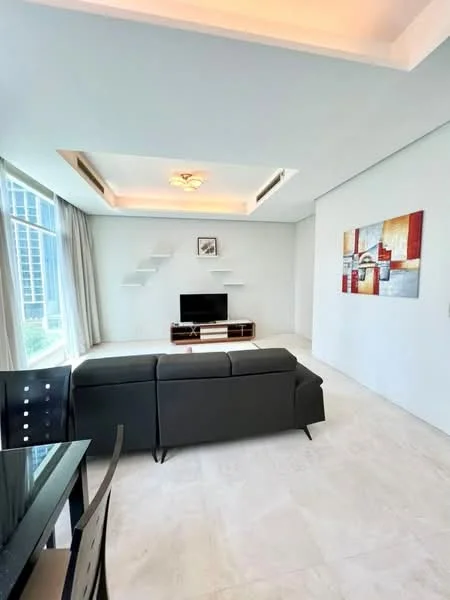 Living features: grey leather sofa, coffee table, wall-mounted TV, TV console, shelves on wall, recessed ceiling lights, large floor-to-ceiling windows, curtains, marble flooring, decorative artwork on wall; style: modern; view: city.