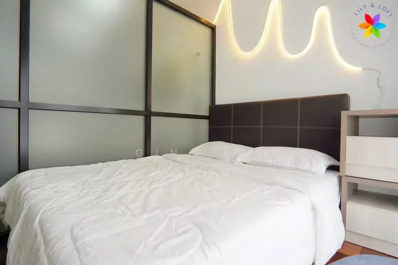 Bedroom features: queen-size bed with white bedding, upholstered headboard in dark brown, nightstand with drawer, glass partition wall, wooden flooring, decorative wall lighting, white walls, window with sheer curtains; style: modern.