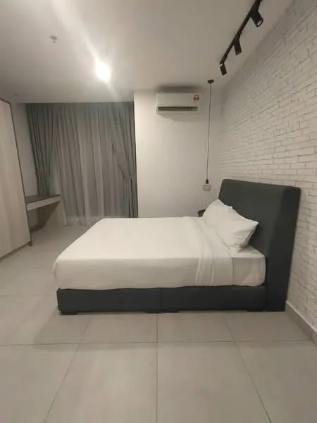 Bedroom features: king-size bed with grey upholstered headboard, white bedding, white walls with exposed brick accent wall, grey tiled flooring, floor-to-ceiling windows with sheer curtains, 1 wall-mounted split AC, recessed ceiling lights, study desk, built-in wardrobe with sliding doors; style: modern.