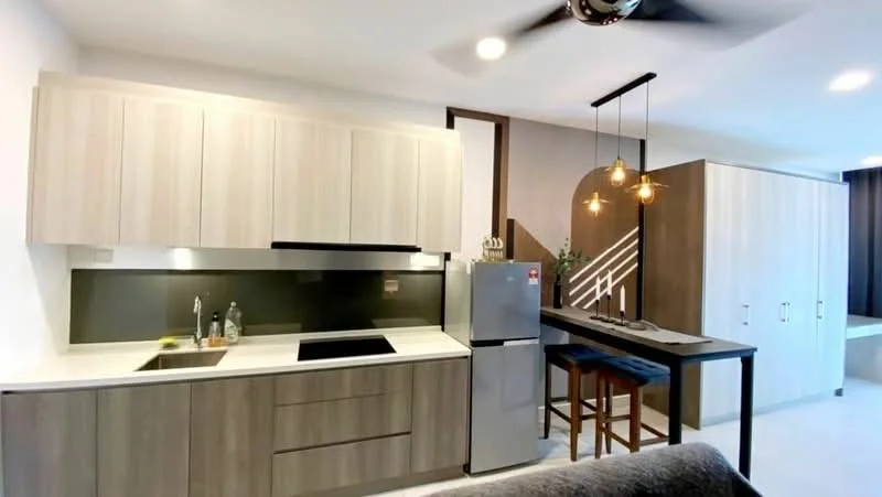 Kitchen features: light wood cabinetry, white countertop, black induction cooktop, stainless-steel fridge, single-bowl stainless-steel sink, chrome pull-down faucet, pendant lighting, bar seating with stools, open shelving, grey accent wall, recessed downlights, floor-to-ceiling windows; style: modern.