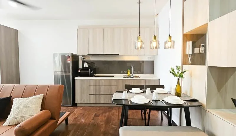 Kitchen features: light wood cabinetry, grey countertop, stainless-steel fridge, built-in oven, 4-burner gas hob, chrome pull-down faucet, single-bowl stainless-steel sink, pendant lighting, open shelving, dining table with 4 chairs, wood flooring, wall-mounted kitchen appliances; style: modern. Living features: 3-seater fabric sofa in brown, decorative cushions, coffee table, area rug, wall-mounted TV, wood flooring; style: modern.
