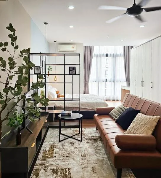Living features: 3-seater leather sofa in brown, coffee table, TV console, wall-mounted TV, area rug with geometric pattern, ceiling fan, floor-to-ceiling windows, curtains, decorative plant in ceramic pot, wooden flooring, wall-mounted shelving, decorative cushions; style: modern; view: city. Bedroom features: queen-size bed with white bedding, bedside lamps, built-in wardrobe, decorative wall art, natural light from windows; style: modern; view: city.