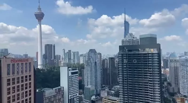 Exterior type: high-rise condominium; features: city skyline view, surrounded by urban landscape, visible landmarks including KL Tower, glass curtain wall, modern architectural design, multiple high-rise buildings, greenery at the base of buildings; style: modern.