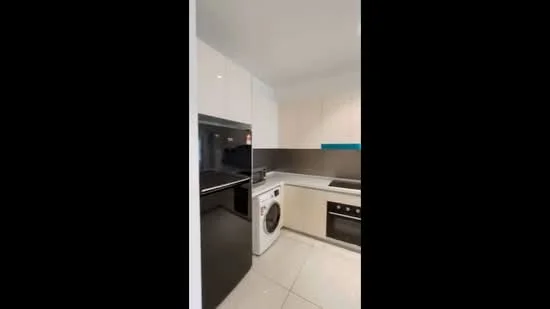 Kitchen features: white high-gloss cabinetry, black countertop, built-in oven, stainless-steel microwave, stainless-steel fridge, front-load washing machine, ceramic tile flooring, recessed downlights, grey backsplash, single-bowl stainless-steel sink, chrome pull-down faucet; style: modern.