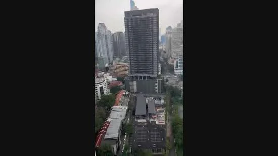 Exterior type: high-rise condominium; features: glass curtain wall, surrounded by mature greenery, parking deck, urban context, adjacent to highway; style: modern.