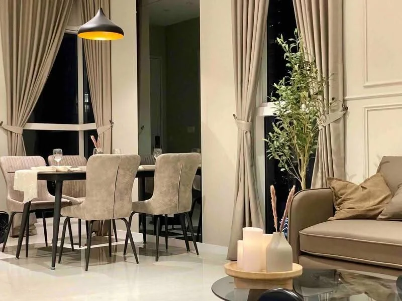 Dining features: 6-seater dining table, upholstered dining chairs in beige, floor-to-ceiling windows, sheer curtains, pendant lamp, decorative plant in vase, neutral wall colour, marble flooring; style: modern; view: city. Living features: fabric sofa in beige, decorative cushions, coffee table, area rug, wall-mounted decor, floor-to-ceiling windows, sheer curtains, neutral wall colour, marble flooring; style: modern; view: city.