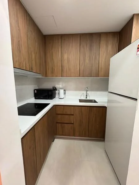 Kitchen features: brown wooden cabinetry, white quartz countertop, single-bowl stainless-steel sink, chrome pull-down faucet, built-in electric cooktop, white refrigerator, microwave, tile backsplash, light-colored tile flooring, under-cabinet lighting; style: modern.
