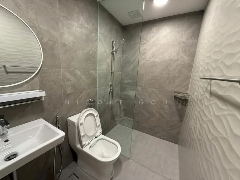 Bathroom features: grey textured wall tiles, white wall-mounted sink, chrome faucet, clear glass shower enclosure, rain shower head, handheld shower, white one-piece toilet, mirror with rounded edges, chrome towel bar, grey floor tiles; style: modern.