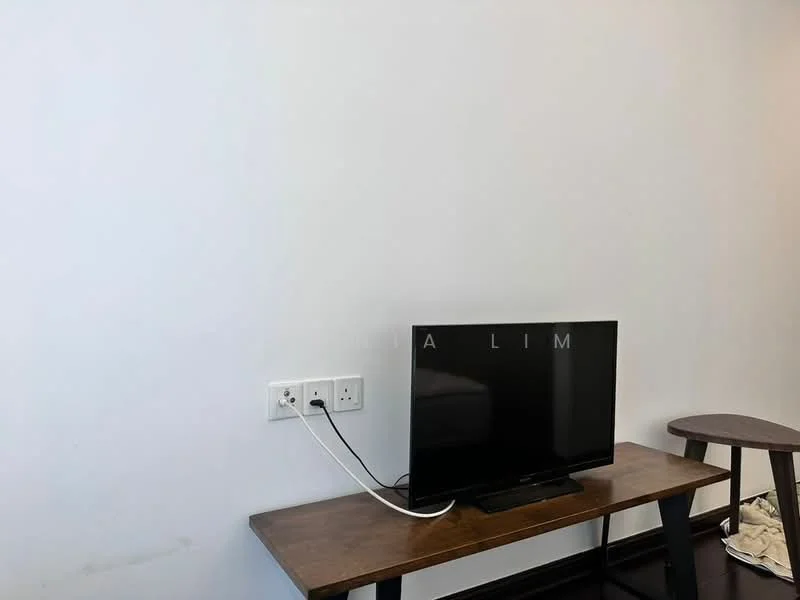 Room features: white painted walls, dark wood table, flat-screen TV, visible electrical outlets, cable management, dark flooring.