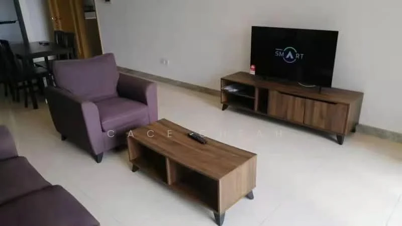 Living features: purple armchair, wooden coffee table, TV console, wall-mounted TV, cream painted walls, tile flooring, recessed lighting, black remote control; style: modern.