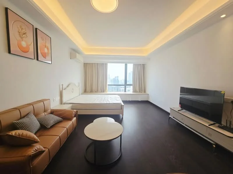 Bedroom features: queen-size bed frame without mattress, brown leather sofa, round coffee table, wall-mounted TV, wooden flooring, white painted walls, recessed ceiling lights, floor-to-ceiling windows with city view, curtains, air conditioning unit; style: modern; view: city.