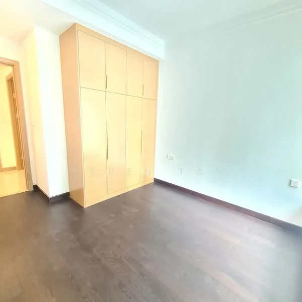 Room features: dark wood flooring, built-in wardrobe with multiple doors, white painted walls, natural light from doorway, no visible ceiling features, no visible window treatments, minimal decor, neutral color scheme; style: modern.