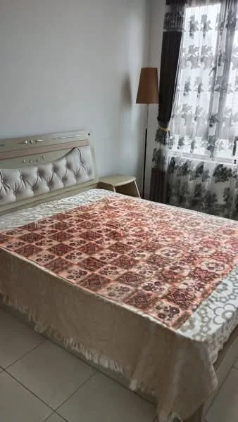 Bedroom features: queen-size bed with upholstered headboard, decorative bedspread with intricate pattern, white painted walls, floor-to-ceiling window with sheer curtains, laminate flooring, side table, table lamp, curtains with floral pattern; style: modern.