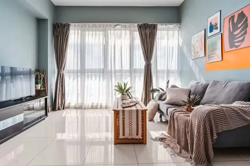 Living features: grey fabric sofa, coffee table with wooden legs, decorative throw blanket, framed artwork on walls, floor-to-ceiling windows, sheer curtains, potted plants, polished ceramic tile flooring; style: modern.