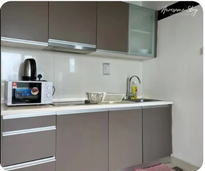 Kitchen features: grey flat-panel cabinets, white countertop, stainless-steel sink, chrome pull-down faucet, built-in microwave, kettle, dish rack, tile backsplash, grey tile flooring; style: modern.