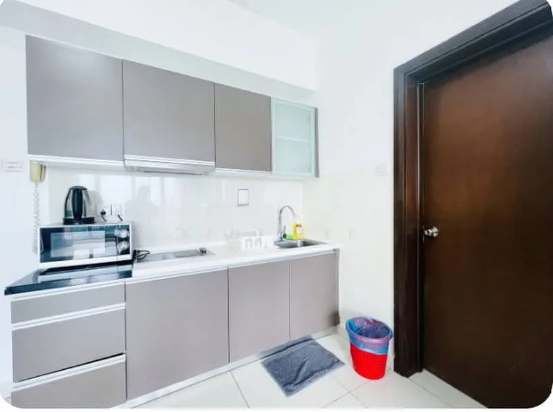 Kitchen features: grey flat-panel cabinets, white countertop, single-bowl stainless-steel sink, chrome pull-down faucet, built-in microwave, freestanding microwave, kettle, tile backsplash, ceramic tile flooring, recessed downlights, door to adjacent room, trash bin; style: modern.