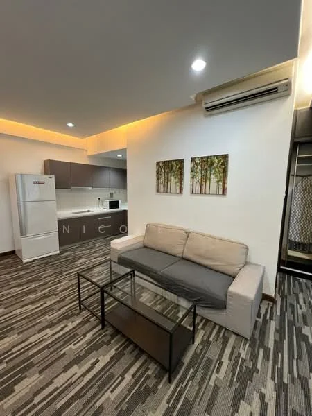 Living features: 3-seater fabric sofa in light grey, glass coffee table with metal frame, wall-mounted split AC, recessed LED downlights, laminate flooring with patterned design, framed artwork with nature theme, open kitchen area visible in background, white painted walls; style: modern. Kitchen features: stainless-steel fridge, grey cabinetry, white countertop, built-in oven, ceramic tile backsplash, open layout to living area; style: modern.