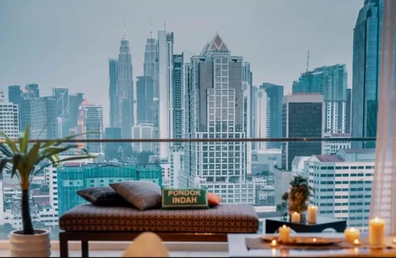 Balcony features: outdoor seating area, decorative cushions, city skyline view, glass railing, potted plant, candles, wooden flooring, table with decorative items; style: modern; view: city.