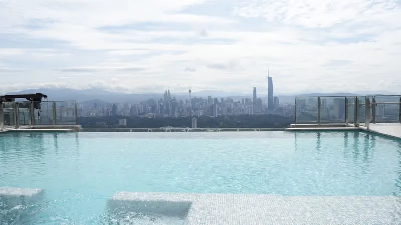 Exterior type: high-rise condominium; features: infinity pool, pool deck with loungers, city skyline view, glass railing, tiled pool surface, surrounding urban landscape; style: modern.
