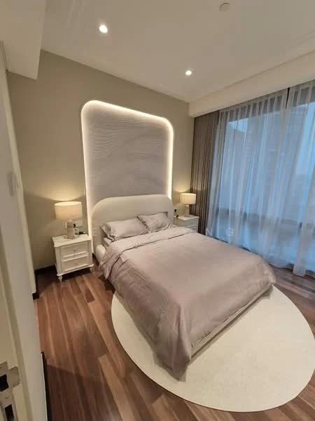 Bedroom features: king-size bed with upholstered headboard, bedding in light grey, two bedside lamps with white shades, wooden flooring, round area rug in cream, floor-to-ceiling windows with sheer curtains, wall-mounted feature lighting behind headboard, neutral painted walls; style: modern; view: city.