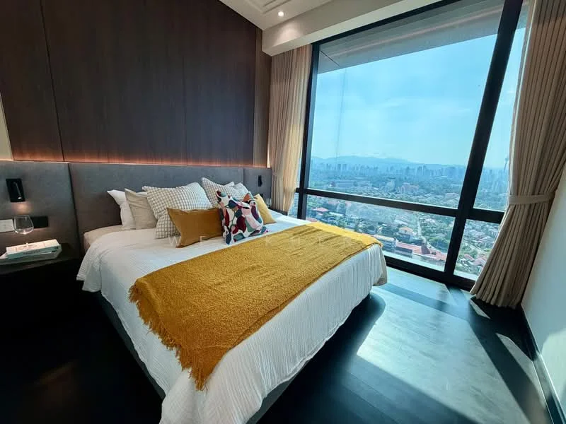 Bedroom features: king-size bed with white bedding, upholstered headboard, decorative throw pillows, yellow throw blanket, floor-to-ceiling windows, city skyline view, dark wood accent wall, laminate flooring, nightstand with glass of wine, sheer curtains, recessed lighting; style: modern; view: city.