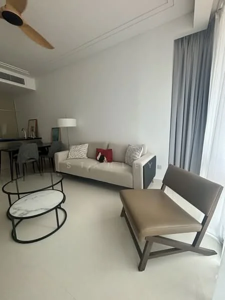 Living features: 3-seater fabric sofa in light grey, coffee table with marble top, wooden chair with brown upholstery, floor-to-ceiling windows with sheer curtains, light-colored walls, white tiled flooring, ceiling fan, decorative cushions, bar counter in background, pendant lighting; style: modern.