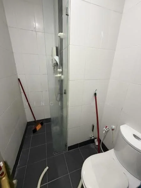 Bathroom features: white tiled walls, grey tiled flooring, walk-in shower with glass enclosure, chrome handheld shower, one-piece toilet, shower hose, shower valve, cleaning supplies visible.