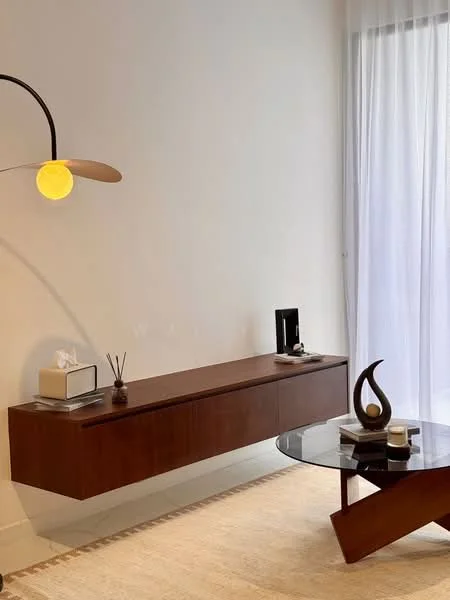 Living features: wooden wall-mounted console, round glass coffee table, floor lamp with a circular shade, decorative vase, decorative sculpture, tissue box, neutral wall color, sheer curtains; style: modern.