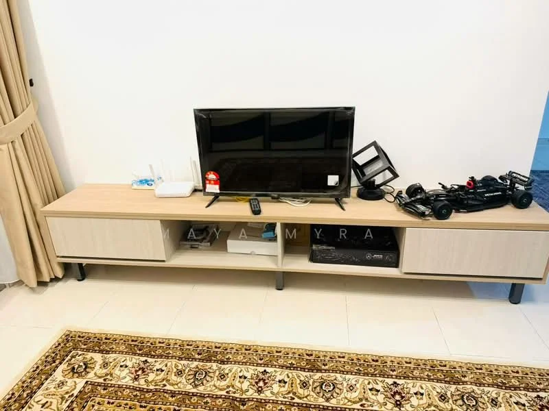 Living features: light wood TV console, flat-screen TV, remote control, decorative black lamp, small black toy car, cream wall, beige curtains, area rug with intricate pattern, tile flooring; style: modern.
