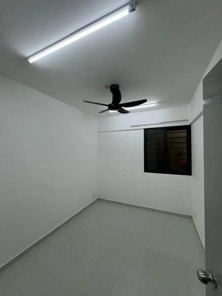 Room features: white painted walls, grey tiled flooring, 5-blade ceiling fan, single window with black grille, LED strip lighting, no visible furniture, minimalist decor, corner room; style: minimalist.