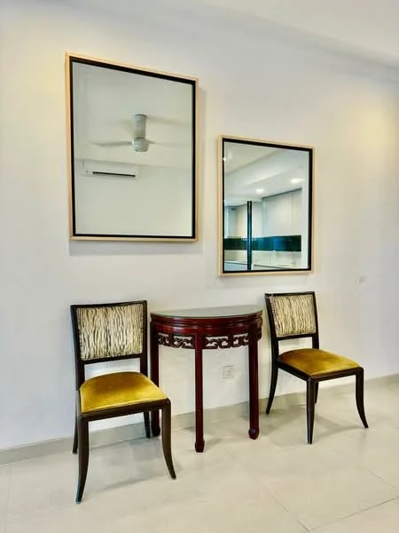 Room features: 2 wooden chairs with upholstered seats in yellow, round wooden console table with decorative design, 2 framed mirrors on the wall, white painted walls, light-colored tiled flooring, 1 ceiling fan, 1 wall-mounted air conditioning unit; style: modern.
